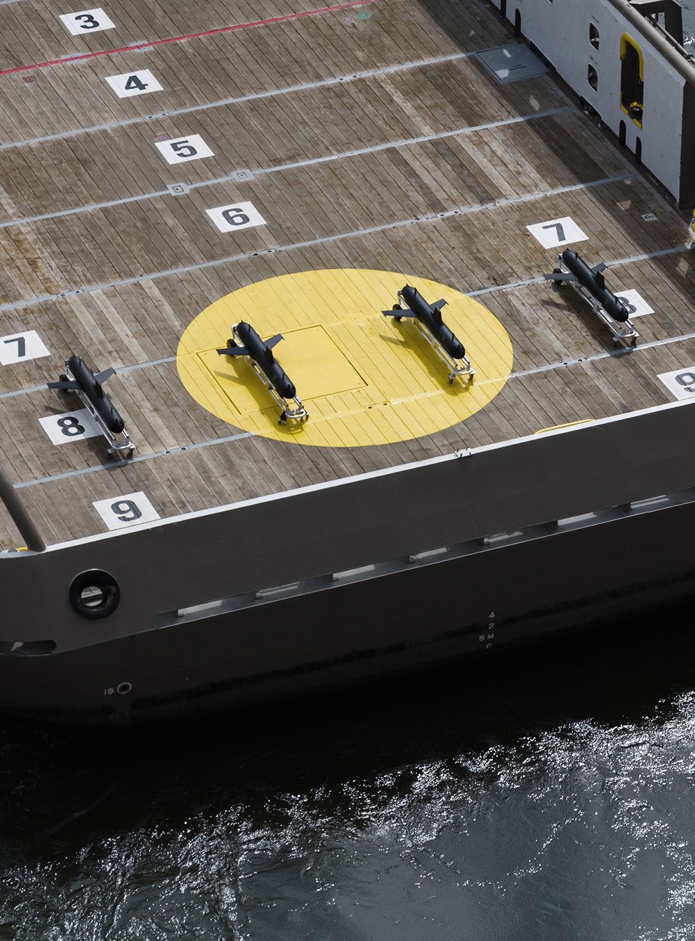 A picture showing four underwater gliders on a vessel, drone view