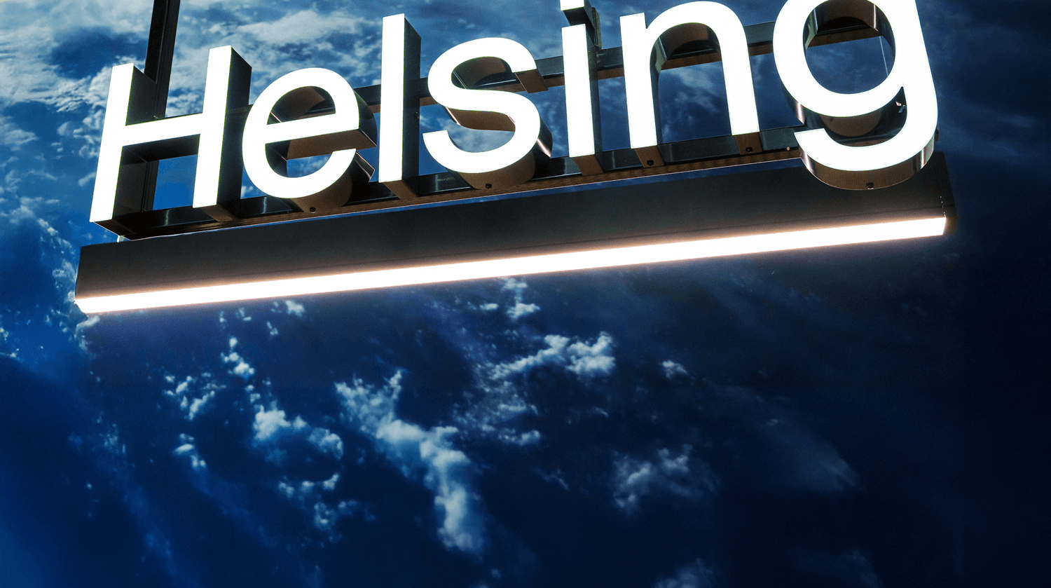 An illuminated sign of the Helsing logo