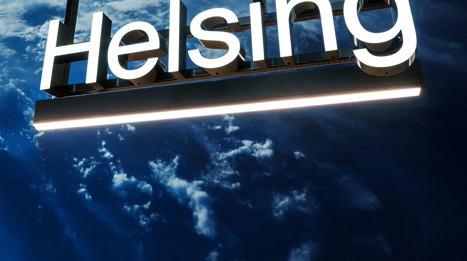 An illuminated sign of the Helsing logo