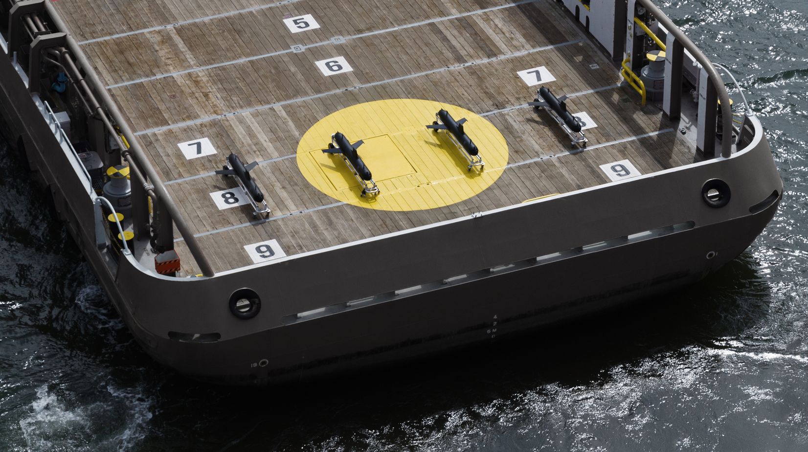 An picture showing four underwater gliders on a vessel, drone view